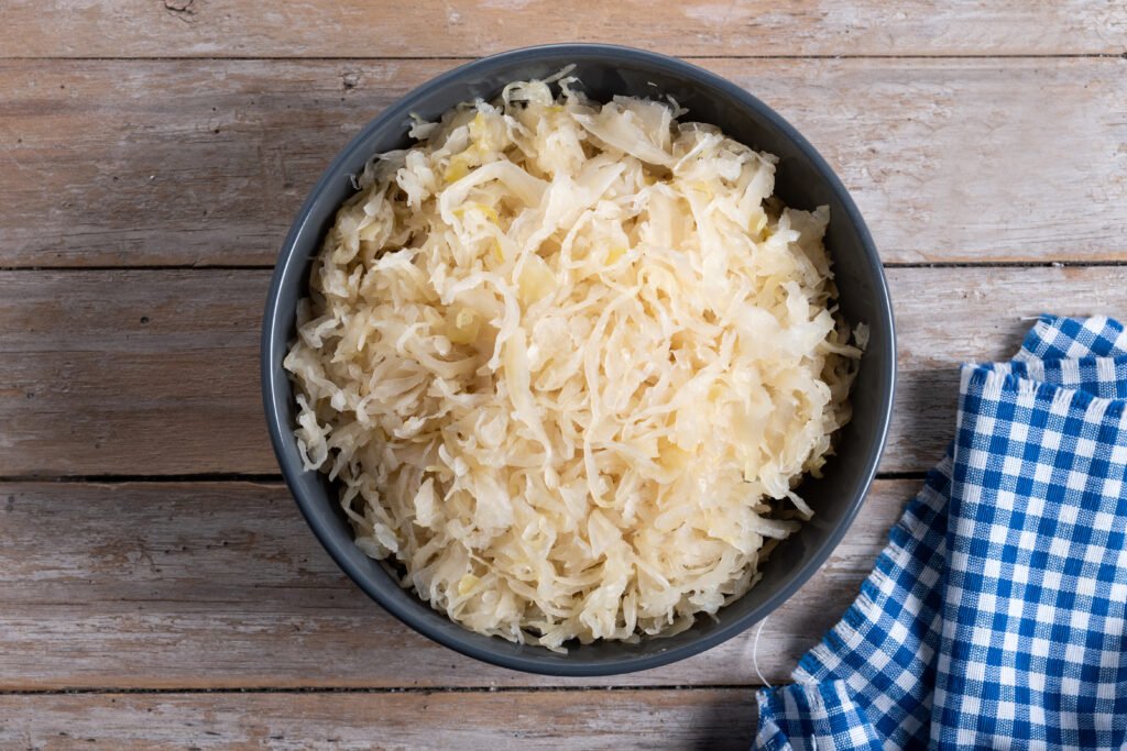 sauerkraut in a bowl on wooden table. traditional german food
