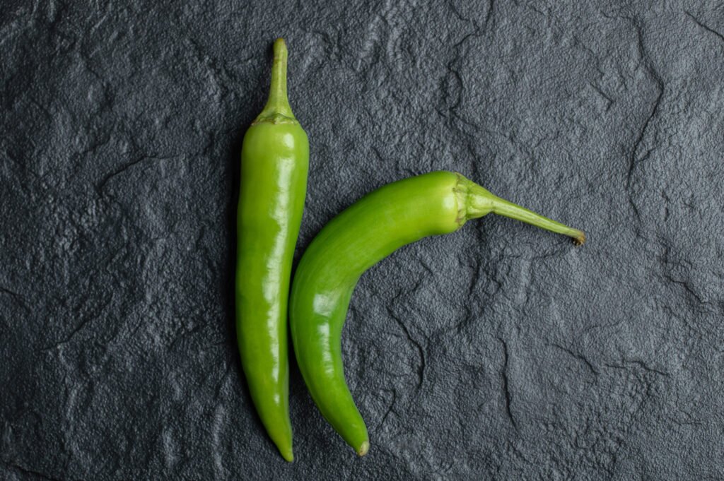 top view of fresh hot peppers on black background