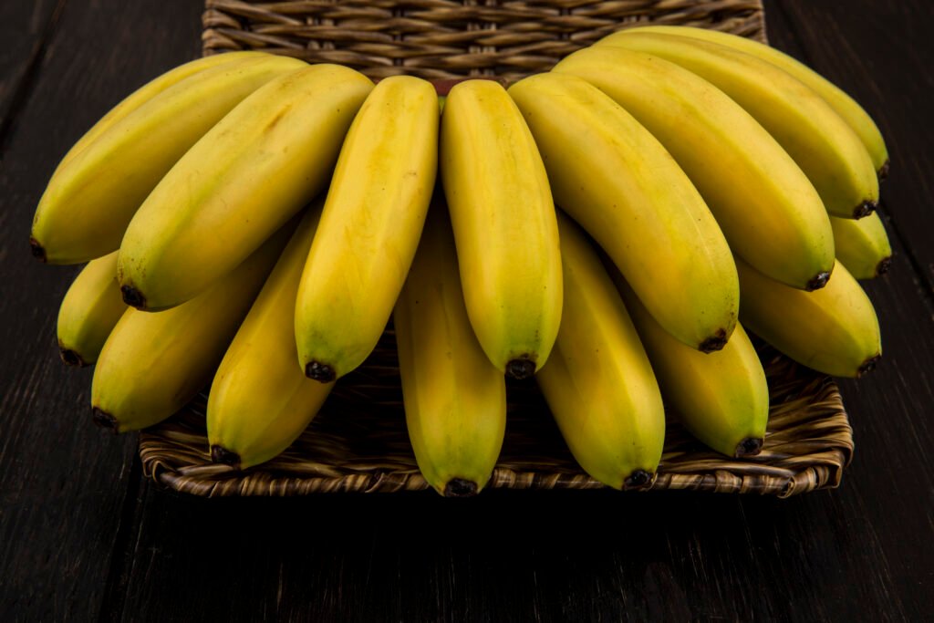 side view of bunch of bananas in a wicker basket on dark background